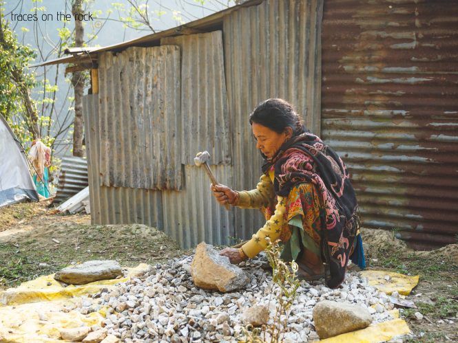 Manaslu Trek - Arketh Bazaar - Nepalese Woman breaks stones Manaslu Trek - Arketh Bazaar - Nepalese Woman breaks stones