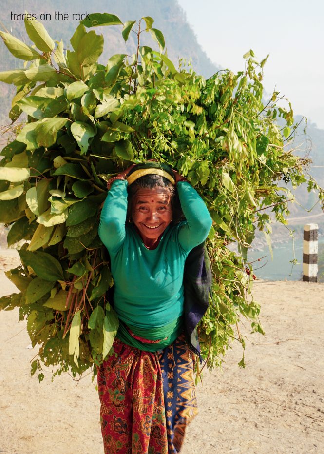 Manaslu Trek - Arketh Bazaar - Nepalese woman carries leaves Manaslu Trek - Arketh Bazaar - Nepalese woman carries leaves